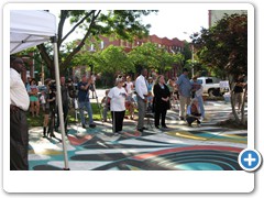 Members of the press, local government and community members watch the dedication ceremony.